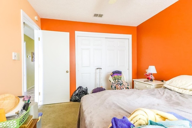 bedroom featuring carpet, a closet, and a textured ceiling