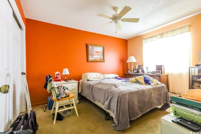 carpeted bedroom with ceiling fan, a textured ceiling, and a closet