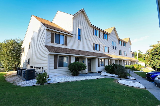 view of front of home with central AC unit and a front yard