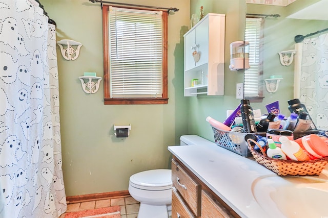 bathroom with vanity, toilet, a shower with shower curtain, and tile patterned floors