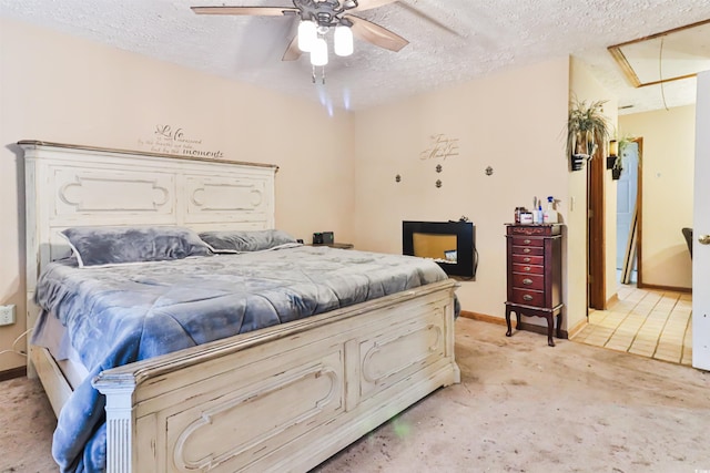 carpeted bedroom featuring ceiling fan and a textured ceiling