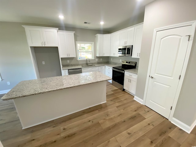 kitchen with white cabinets, stainless steel appliances, and a kitchen island