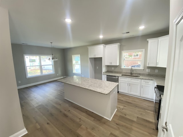 kitchen featuring a center island, white cabinetry, an inviting chandelier, and a sink