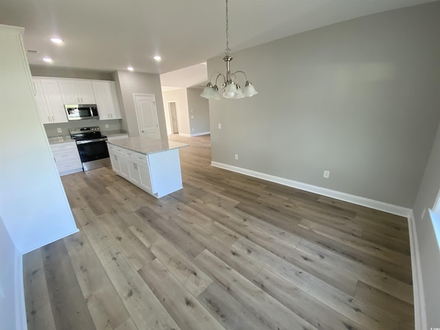 kitchen with a notable chandelier, white cabinetry, stainless steel appliances, and light wood-style floors