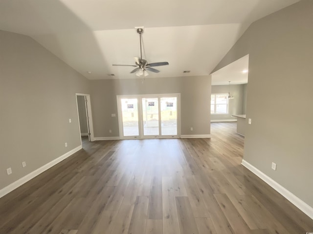 unfurnished living room featuring wood finished floors, visible vents, baseboards, ceiling fan, and vaulted ceiling