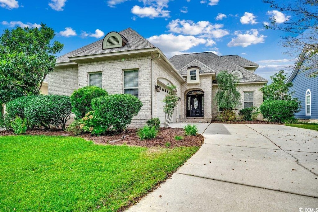 french country home featuring a front lawn