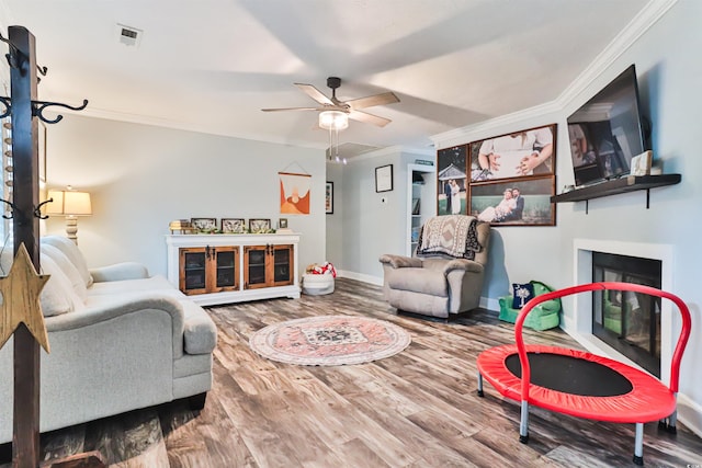 living room featuring ceiling fan, hardwood / wood-style floors, and crown molding