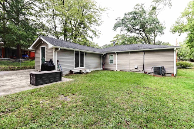 back of property featuring central AC, a patio area, and a yard