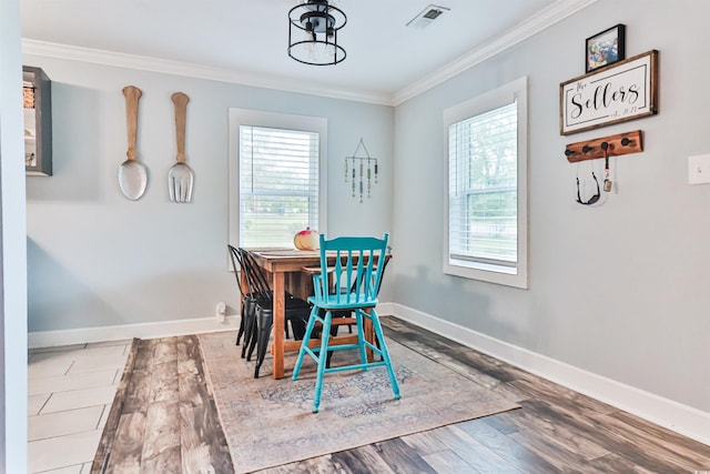 dining area featuring hardwood / wood-style flooring and crown molding