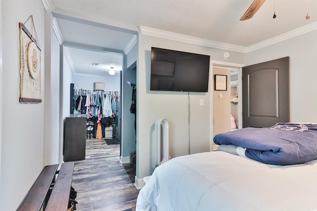 bedroom with ornamental molding, a closet, hardwood / wood-style flooring, and ceiling fan