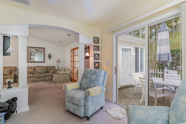 sitting room featuring vaulted ceiling, decorative columns, and light carpet