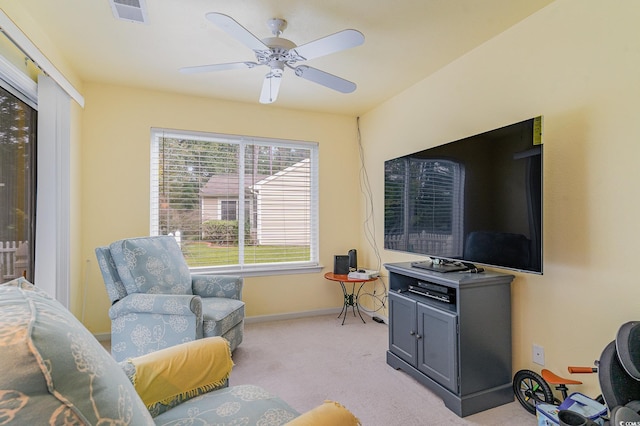 living area featuring light colored carpet and ceiling fan