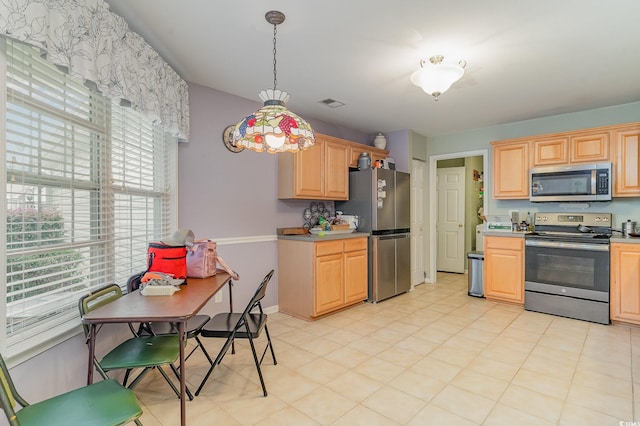 kitchen featuring stainless steel appliances, hanging light fixtures, and light brown cabinets