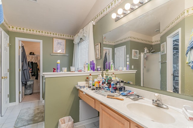 bathroom with tile patterned flooring, vanity, vaulted ceiling, and a shower with shower door