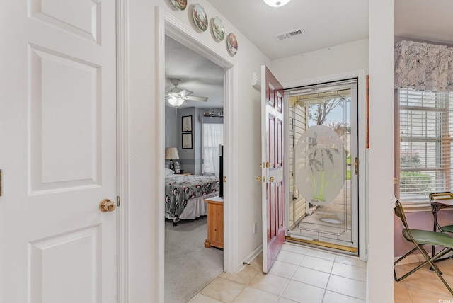 foyer entrance featuring light tile patterned floors, plenty of natural light, and ceiling fan