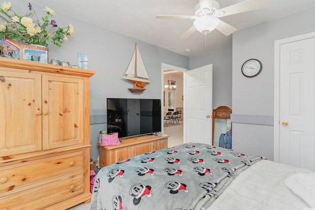 bedroom with ceiling fan with notable chandelier