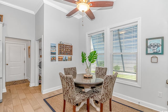 dining space featuring ornamental molding, ceiling fan, plenty of natural light, and stacked washing maching and dryer