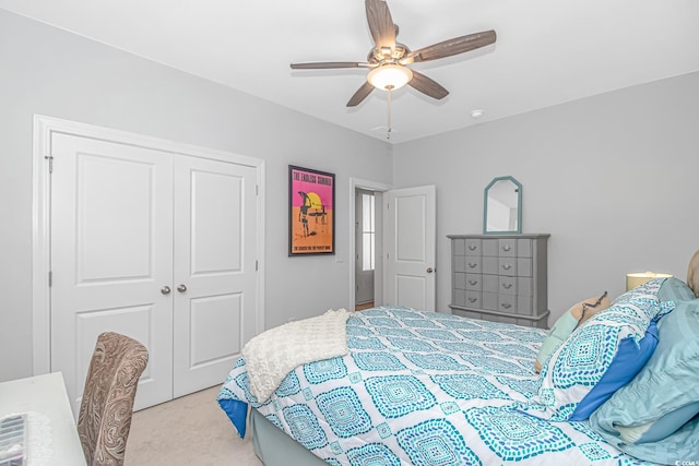 bedroom featuring light carpet, ceiling fan, and a closet