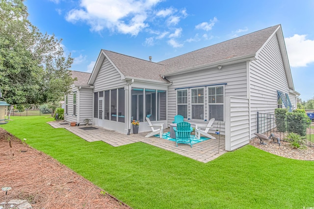 back of house featuring a patio, a yard, and a sunroom