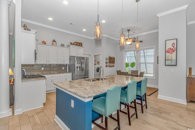 kitchen with an island with sink, white cabinetry, appliances with stainless steel finishes, and sink