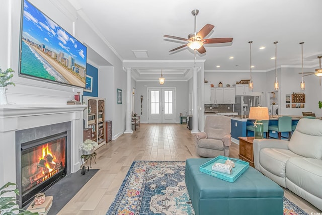 living room with ceiling fan, light hardwood / wood-style flooring, and ornamental molding