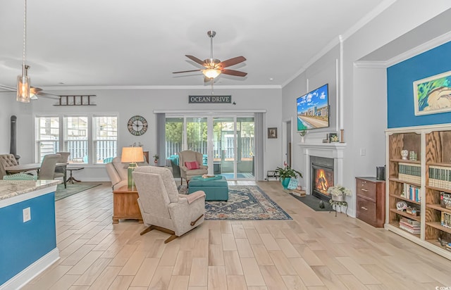 living room featuring light hardwood / wood-style flooring, ceiling fan, and crown molding