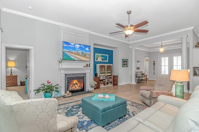 living room with ornamental molding, light wood-type flooring, and ceiling fan