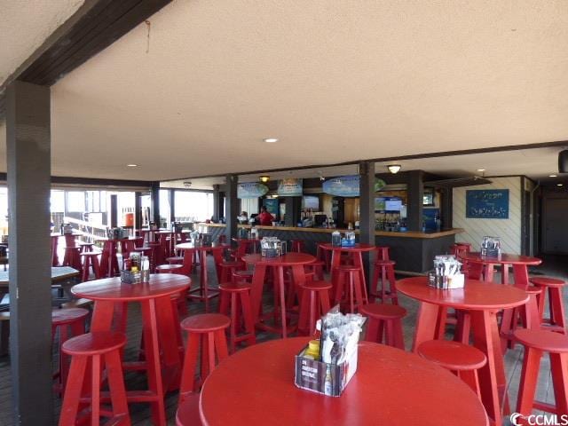 dining area featuring a textured ceiling and bar