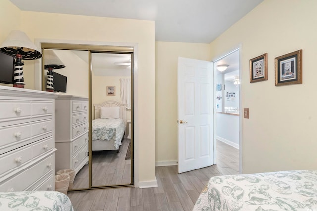 bedroom with light wood-type flooring and a closet