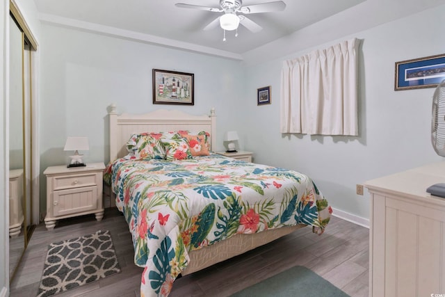 bedroom with dark hardwood / wood-style floors, ceiling fan, and a closet