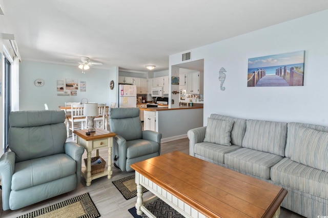 living room with ceiling fan and light hardwood / wood-style flooring