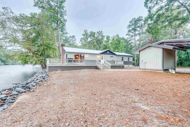 back of property with a deck with water view