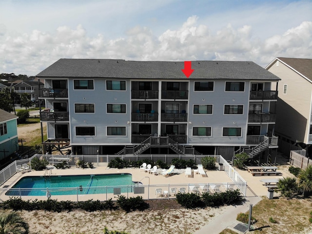 exterior space featuring a community pool and a balcony