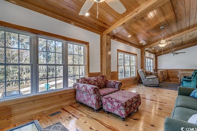 living room with ceiling fan, wood walls, wood-type flooring, and wooden ceiling