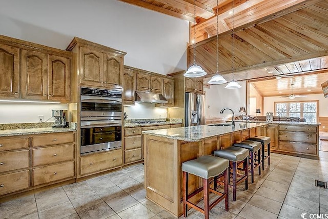 kitchen with wood ceiling, a breakfast bar area, pendant lighting, stainless steel appliances, and a kitchen island with sink