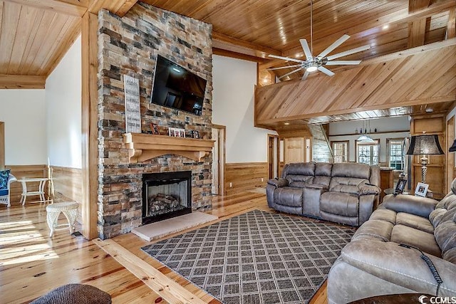 living room featuring wood-type flooring, ceiling fan, wooden ceiling, and a fireplace