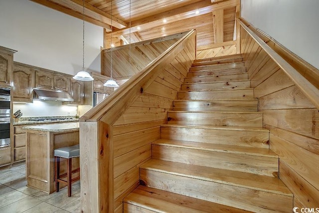 stairs featuring wooden ceiling, wood walls, beam ceiling, and tile patterned floors