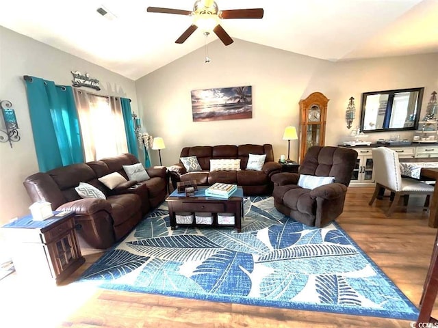 living room featuring lofted ceiling, visible vents, ceiling fan, and wood finished floors