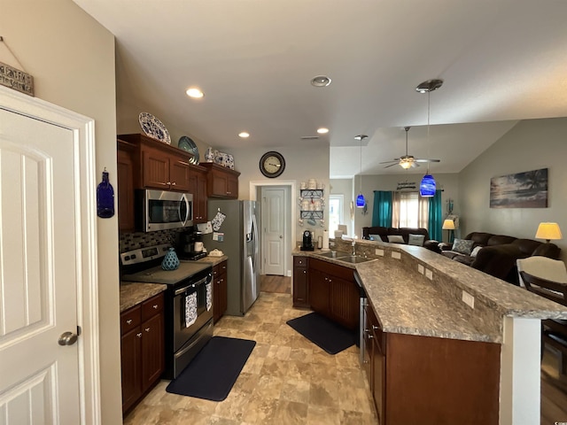 kitchen featuring decorative backsplash, open floor plan, stainless steel appliances, a sink, and recessed lighting