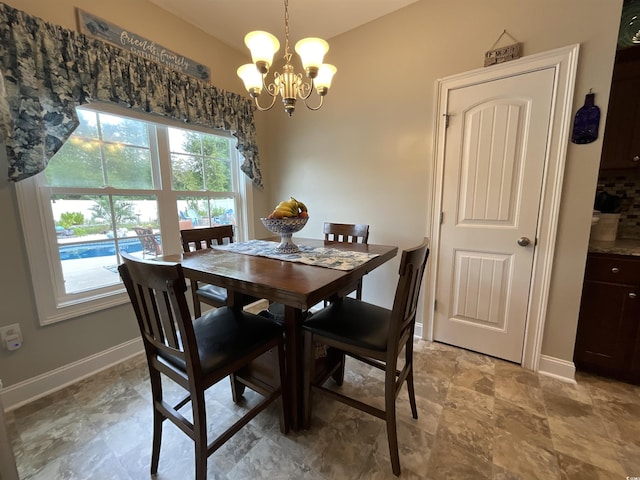 dining room featuring a chandelier and baseboards