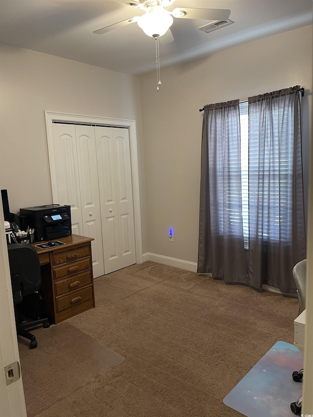 office with carpet floors, ceiling fan, visible vents, and baseboards