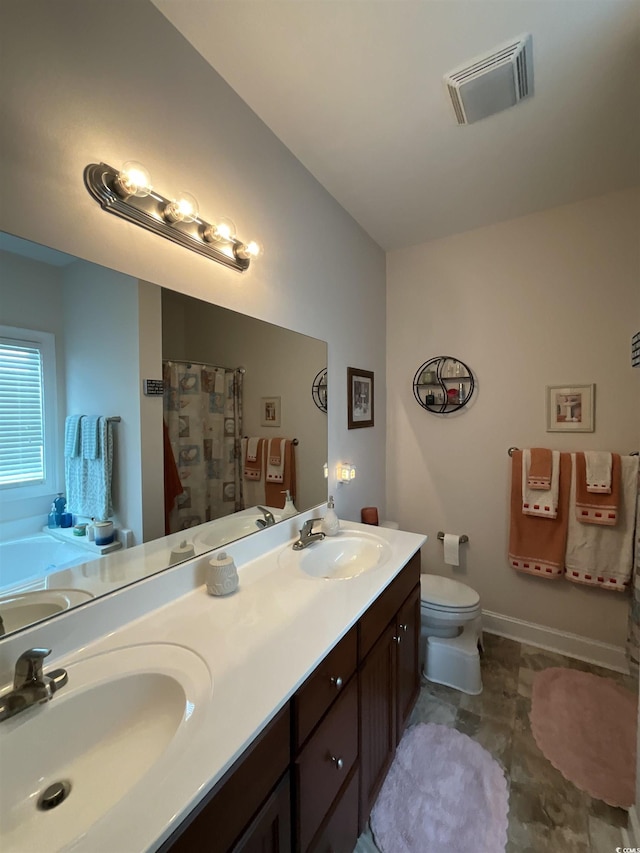 full bathroom with toilet, double vanity, a sink, and visible vents