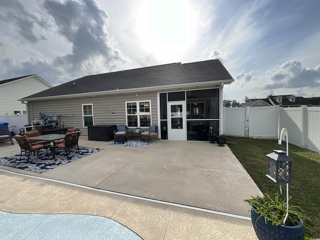 back of property featuring a patio, a sunroom, a gate, fence, and an outdoor living space