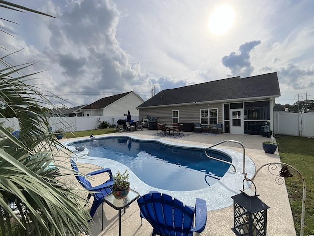 view of swimming pool featuring a fenced in pool, a sunroom, a fenced backyard, and a patio