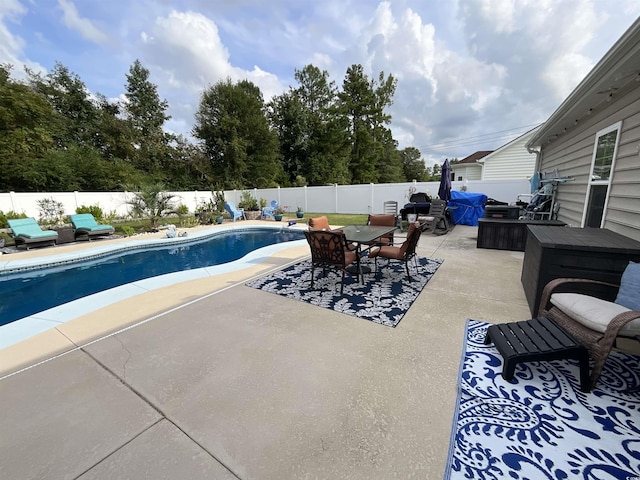 view of pool featuring a fenced in pool, outdoor dining area, a fenced backyard, and a patio