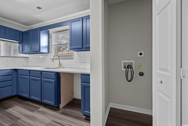 kitchen featuring hardwood / wood-style flooring, ornamental molding, sink, blue cabinetry, and tasteful backsplash