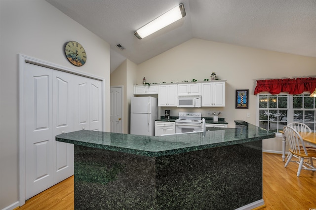 kitchen featuring white cabinets, white appliances, vaulted ceiling, and light wood-type flooring