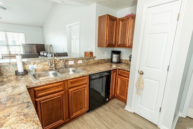 kitchen with light hardwood / wood-style floors, vaulted ceiling, light stone counters, dishwasher, and sink