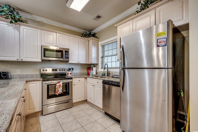 kitchen with light stone counters, sink, stainless steel appliances, light tile patterned floors, and crown molding