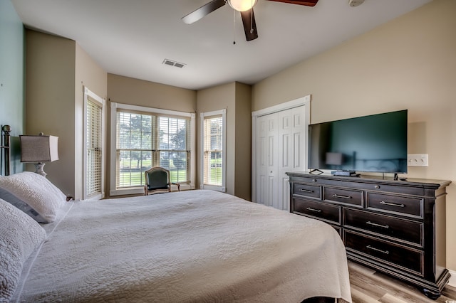 bedroom featuring light hardwood / wood-style floors, ceiling fan, and a closet